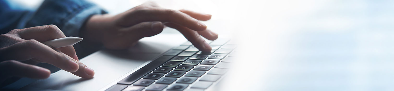 Finger tippen am Laptop auf eine Tastatur