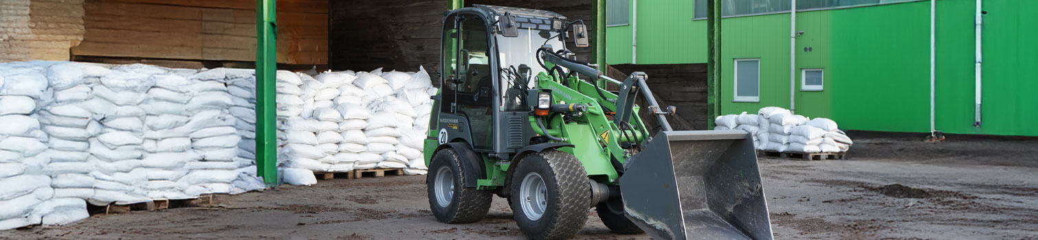 Grüner Radlader steht auf dem Wertstoffhof